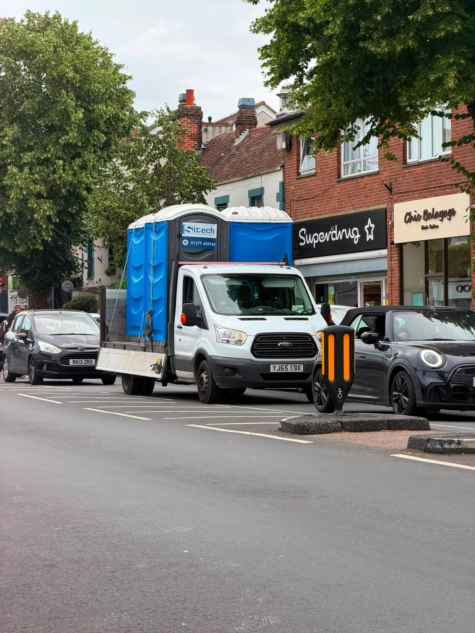 Sitech delivery vehicle carrying portable toilets through a London high street